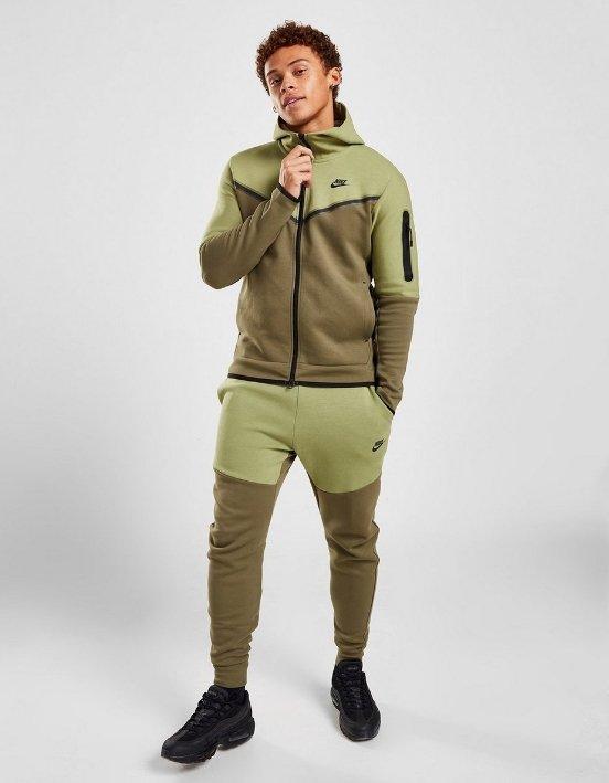 en person som bär svart nike tech fleece