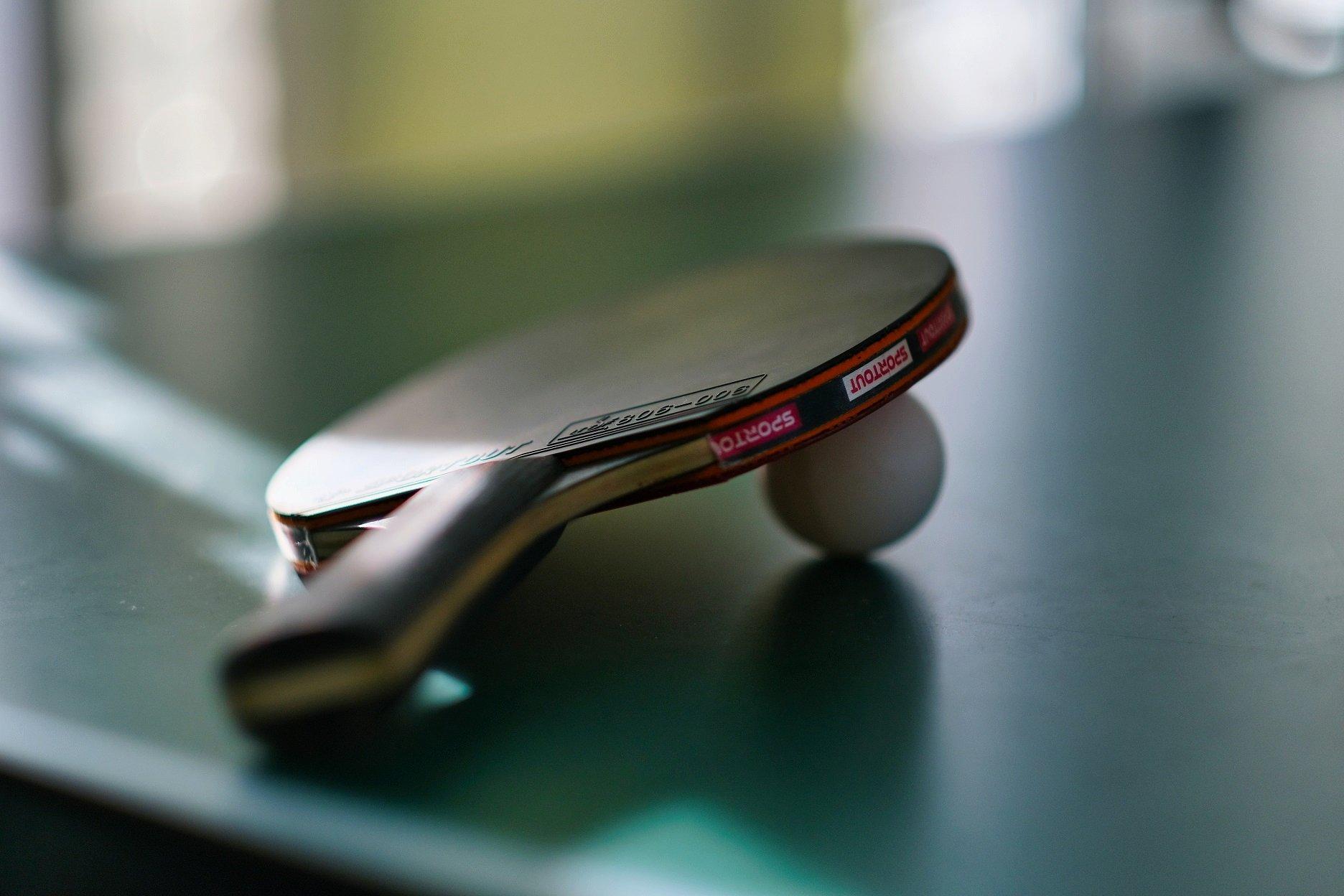 Ping Pong Schläger mit Ball auf Tischtennisplatte