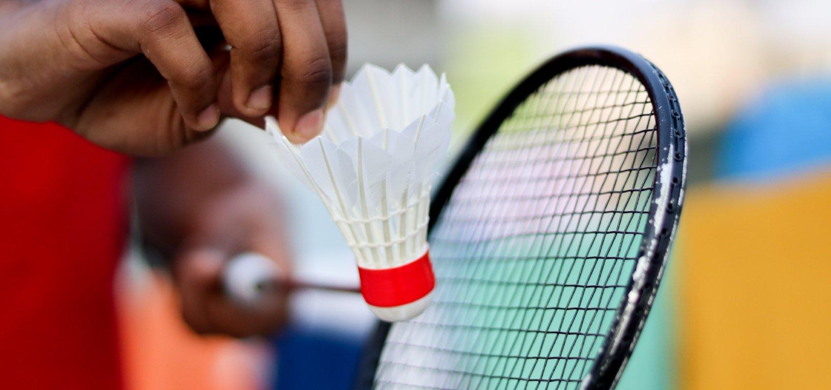 Badminton ketcher med fjerbold.