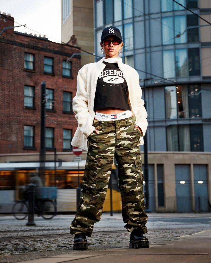 Modelo luciendo un outfit con chaqueta polar blanca y pantalón CAMO con las Thurston Chukka de Dr. Martens