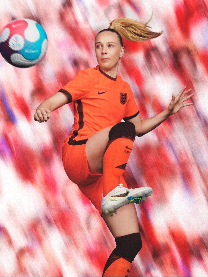 Frau im Sprung beim Fußball spielen in England EM Trikot in Orange