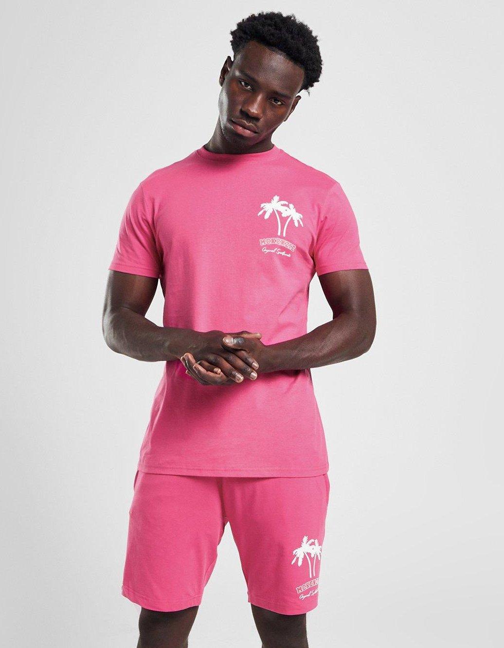 en person i rosa matchande t-shirt och shorts med palmer
