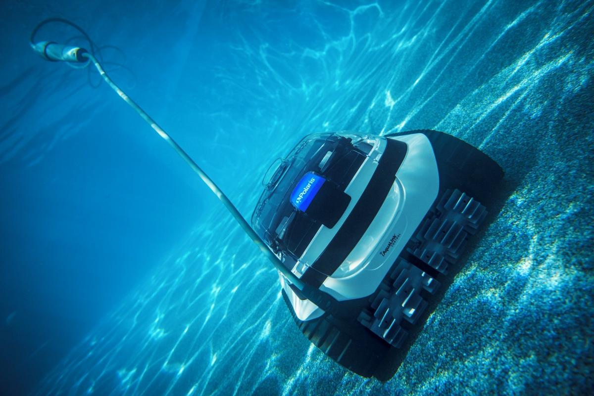 an automatic pool cleaner sitting next to a swimming pool
