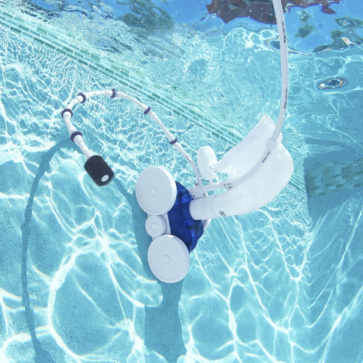 an automatic pool cleaner sitting next to a swimming pool