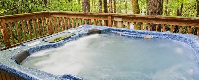 a hot tub on a patio in the forest with bubbling water