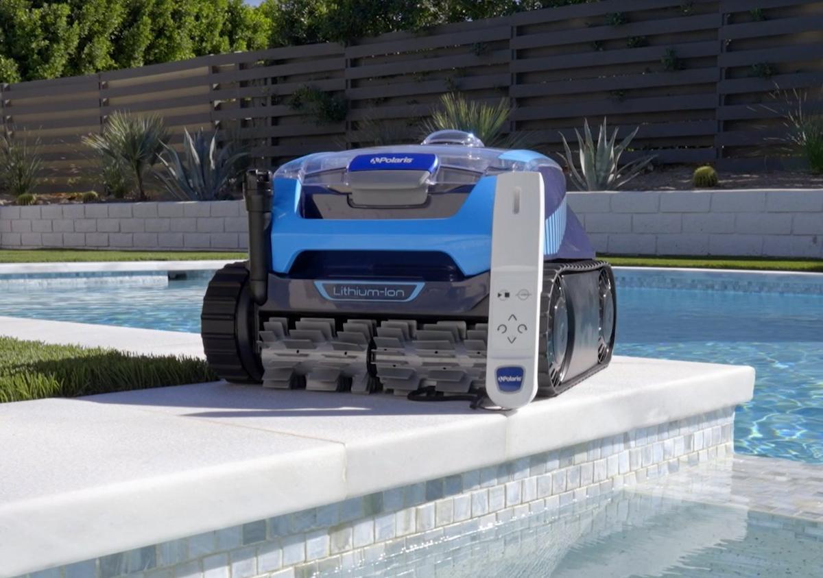 an automatic pool cleaner sitting next to a swimming pool