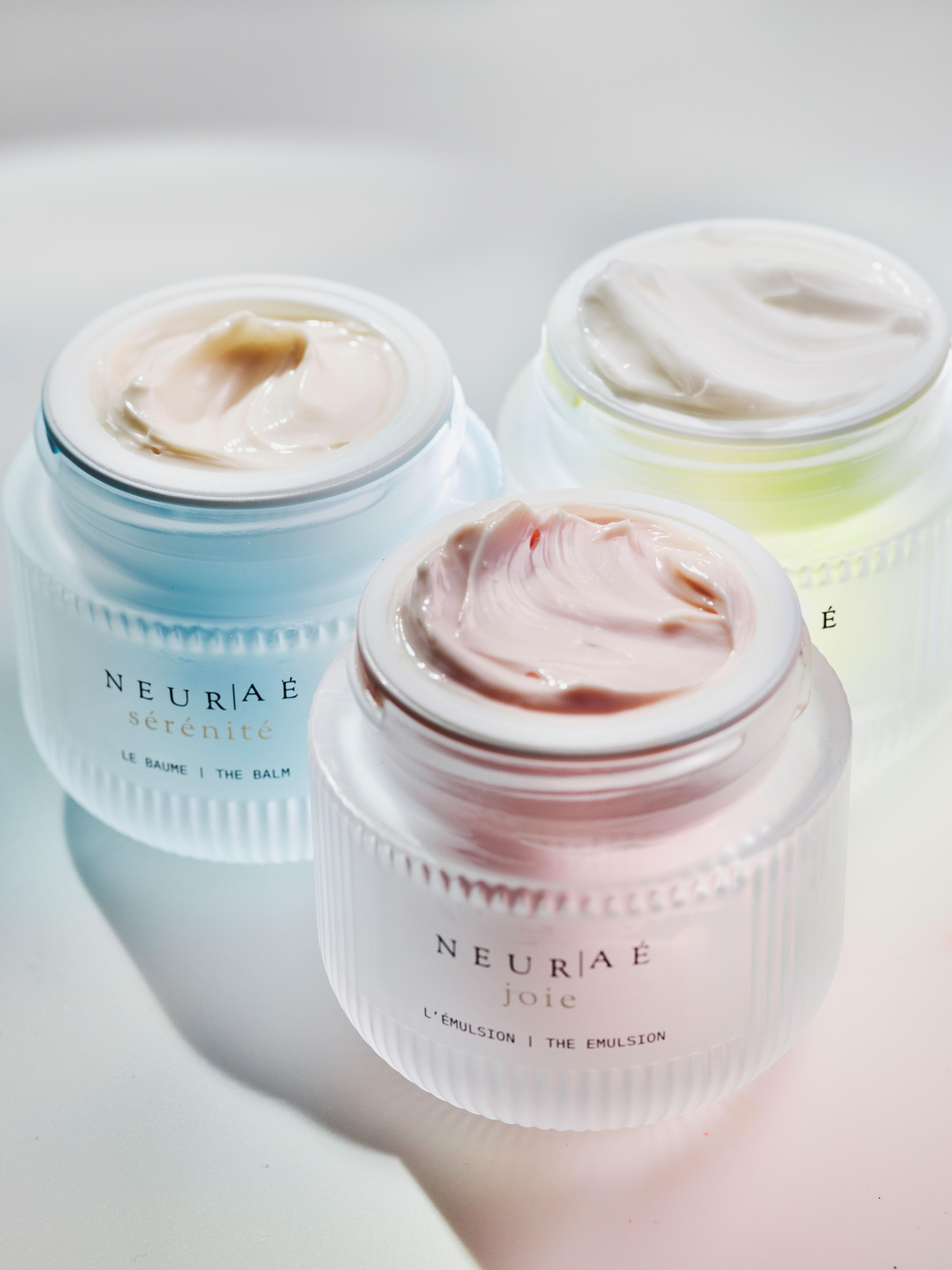 Three jars of product from NEUR|AÉ's collection with the lids removed to show the whipped product texture