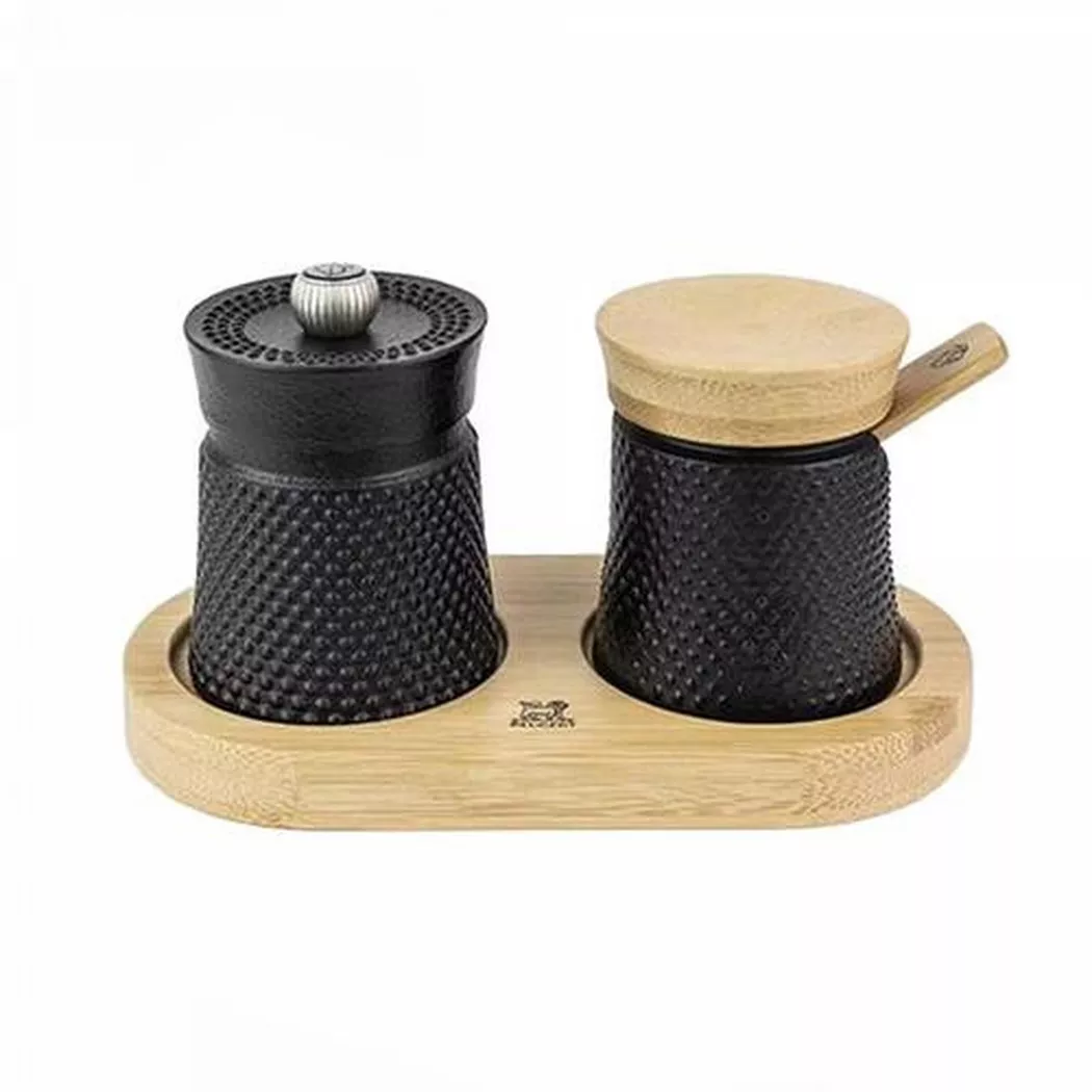 A unique journey through the world of spices: a stylish set comprising a pepper mill and a salt cellar traditionally crafted from cast iron and presented on a storage base adorned with a warm finish. Bali Spice Palace