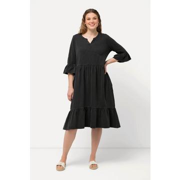 Robe en jersey avec volants. Col tunisien et manches 3/4. Silhouette en A.