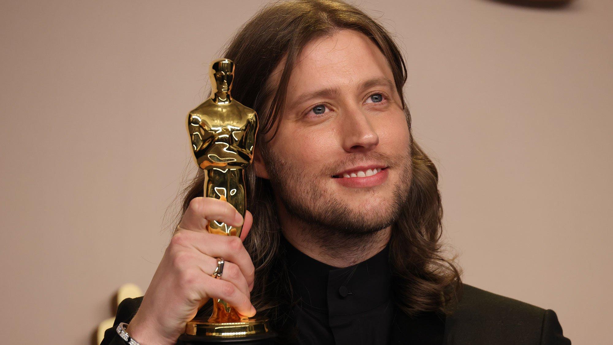 Ludwig Goransson holds his Oscar award for Best Original Score for Oppenheimer.