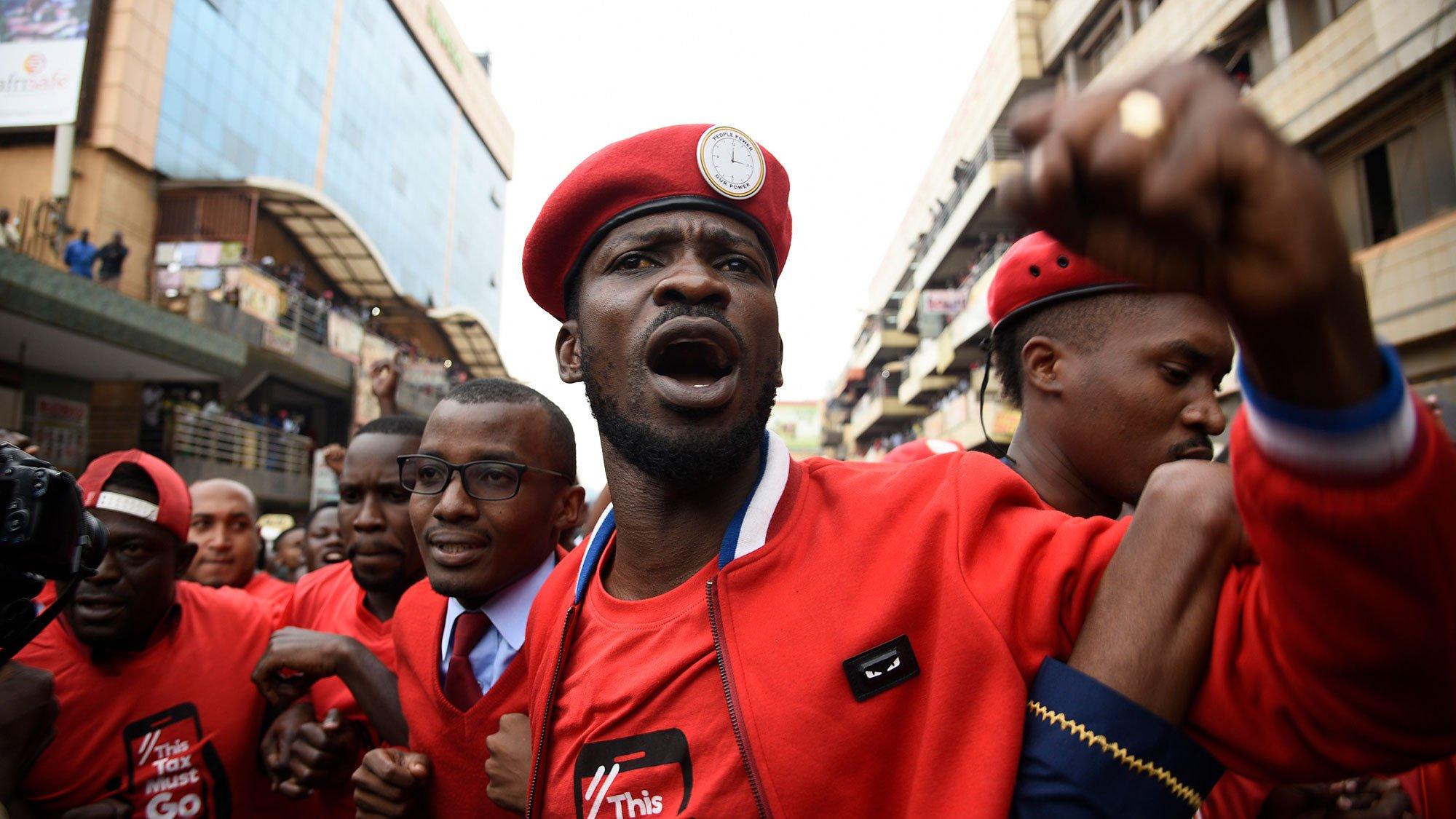 A close-up photo of Bobi Wine shows his fist raised among a crowd during an exchange with Uganda People's Defence Forces and Local Defence Unit after they stopped his procession as he headed for his campaigns on Nov. 30, 2020.