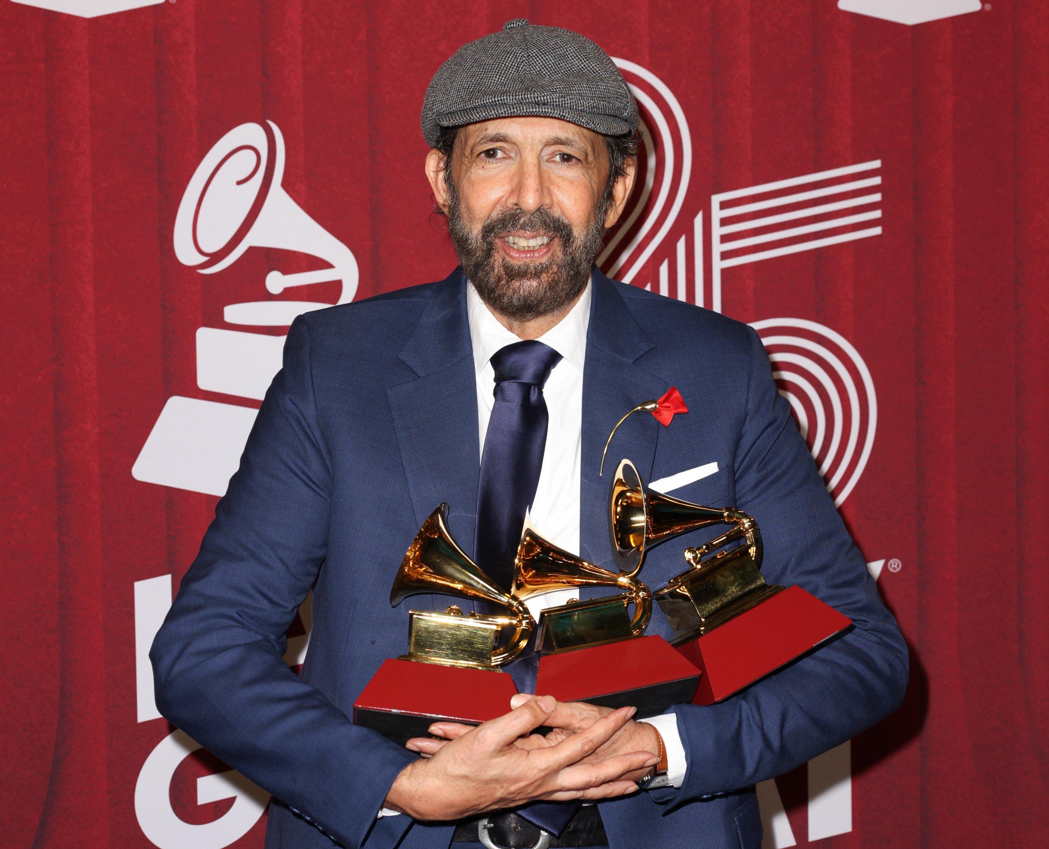 Juan Luis Guerra holding latin grammy awards at the 2024 Latin GRAMMYs