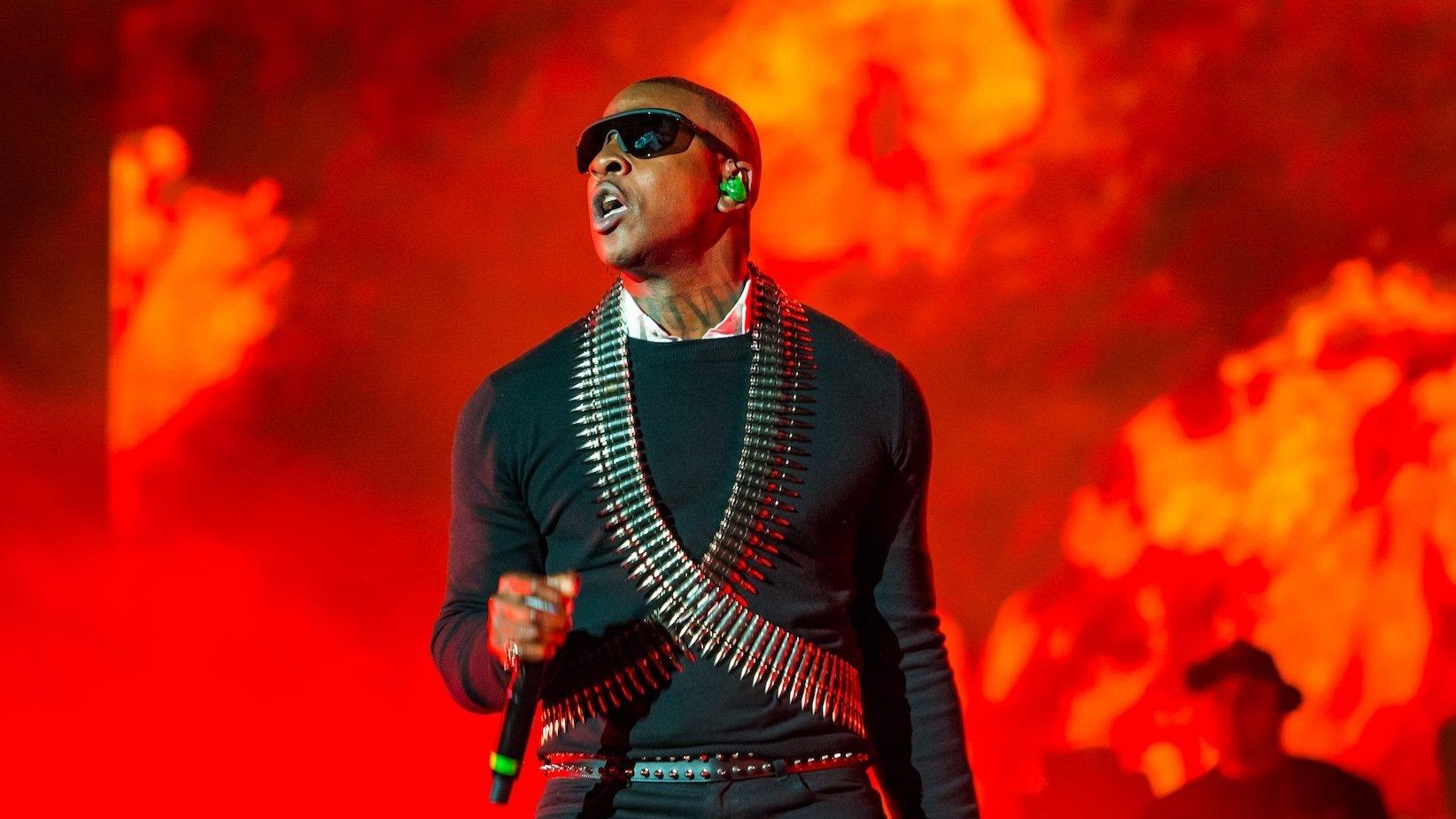 Photo of Skepta performing at Wireless Festival on September 11, 2021, in London, England. Skepta is wearing dark black sunglasses, a black shirt, and a vest made of bullets.