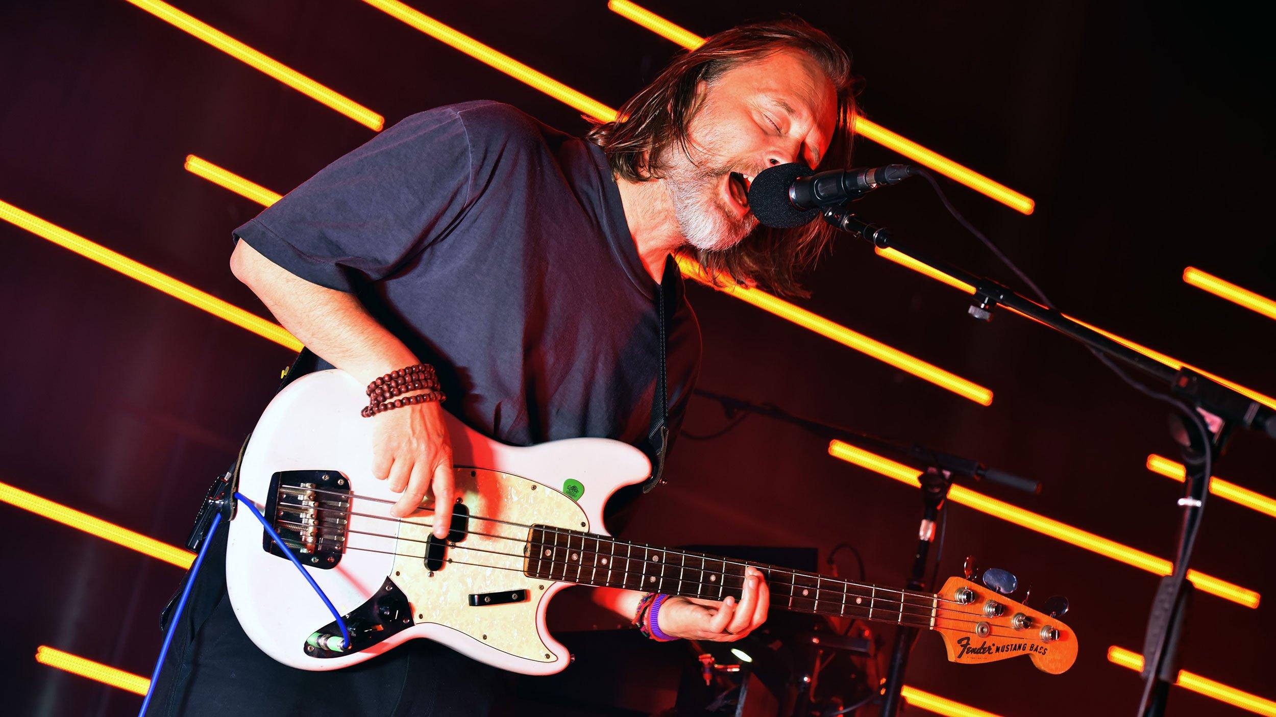 Thom Yorke plays the guitar during a performance with The Smile