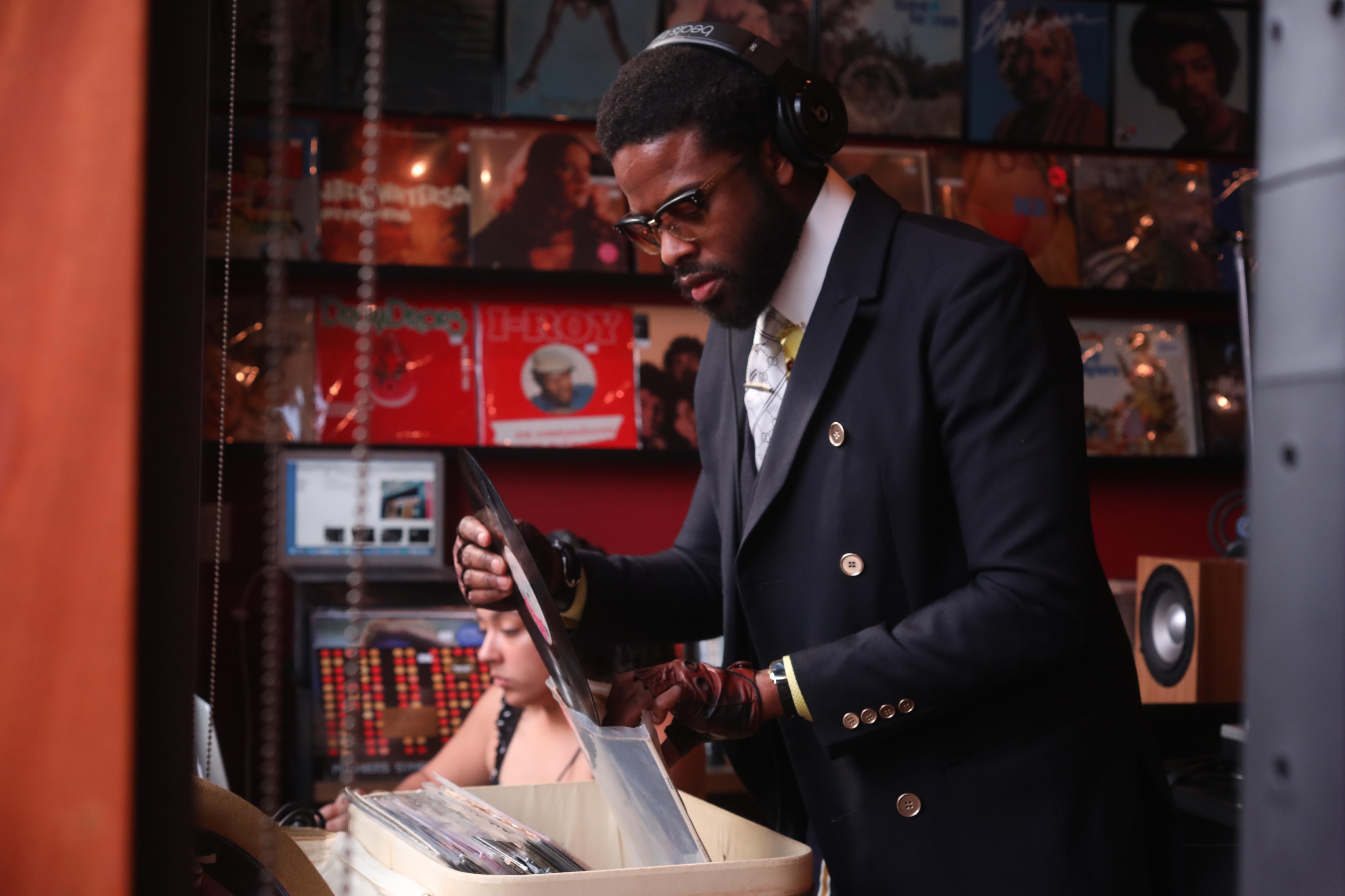 Adrian Younge looks through a box of vinyl