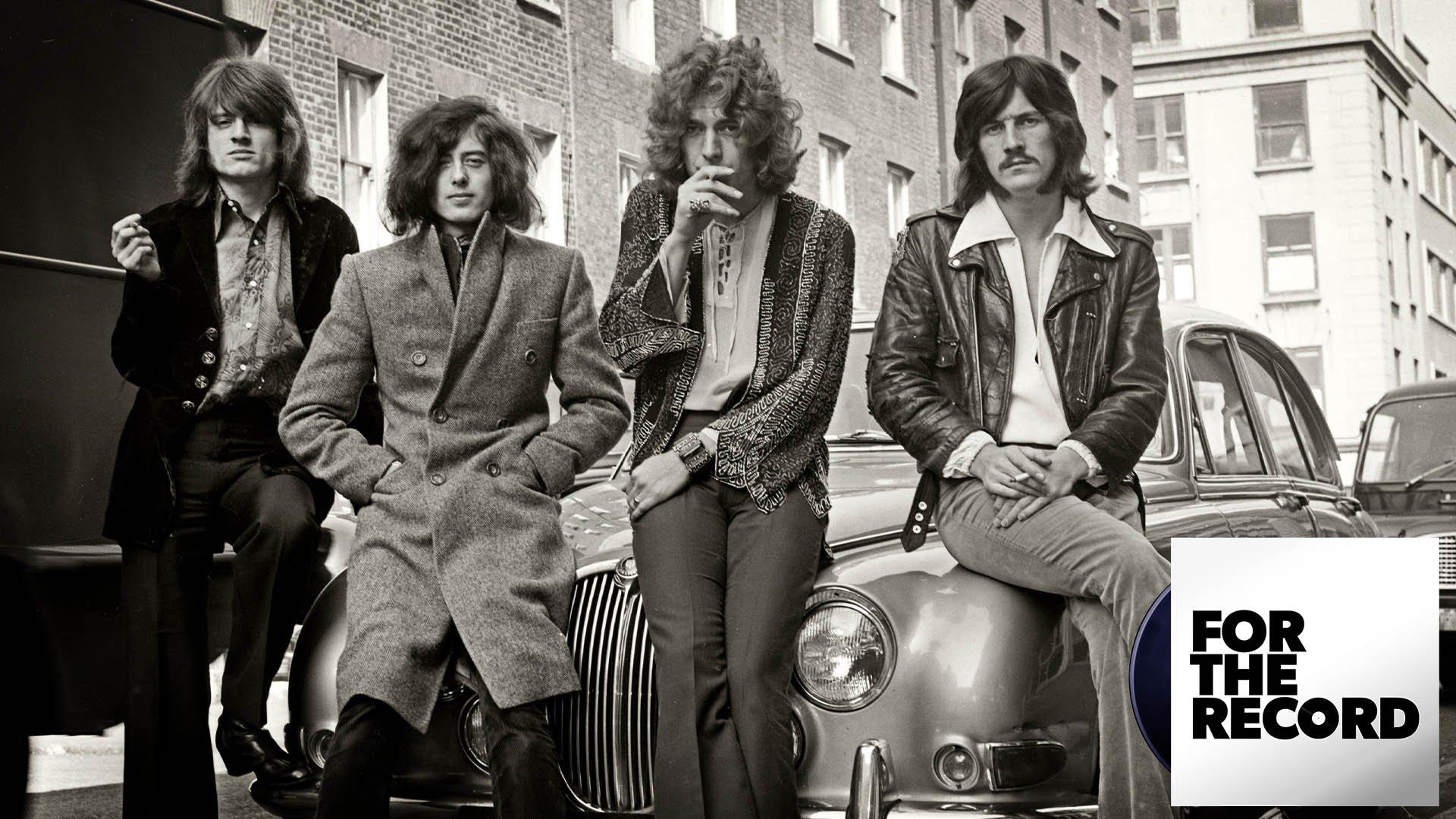 Led Zeppelin posing on a car