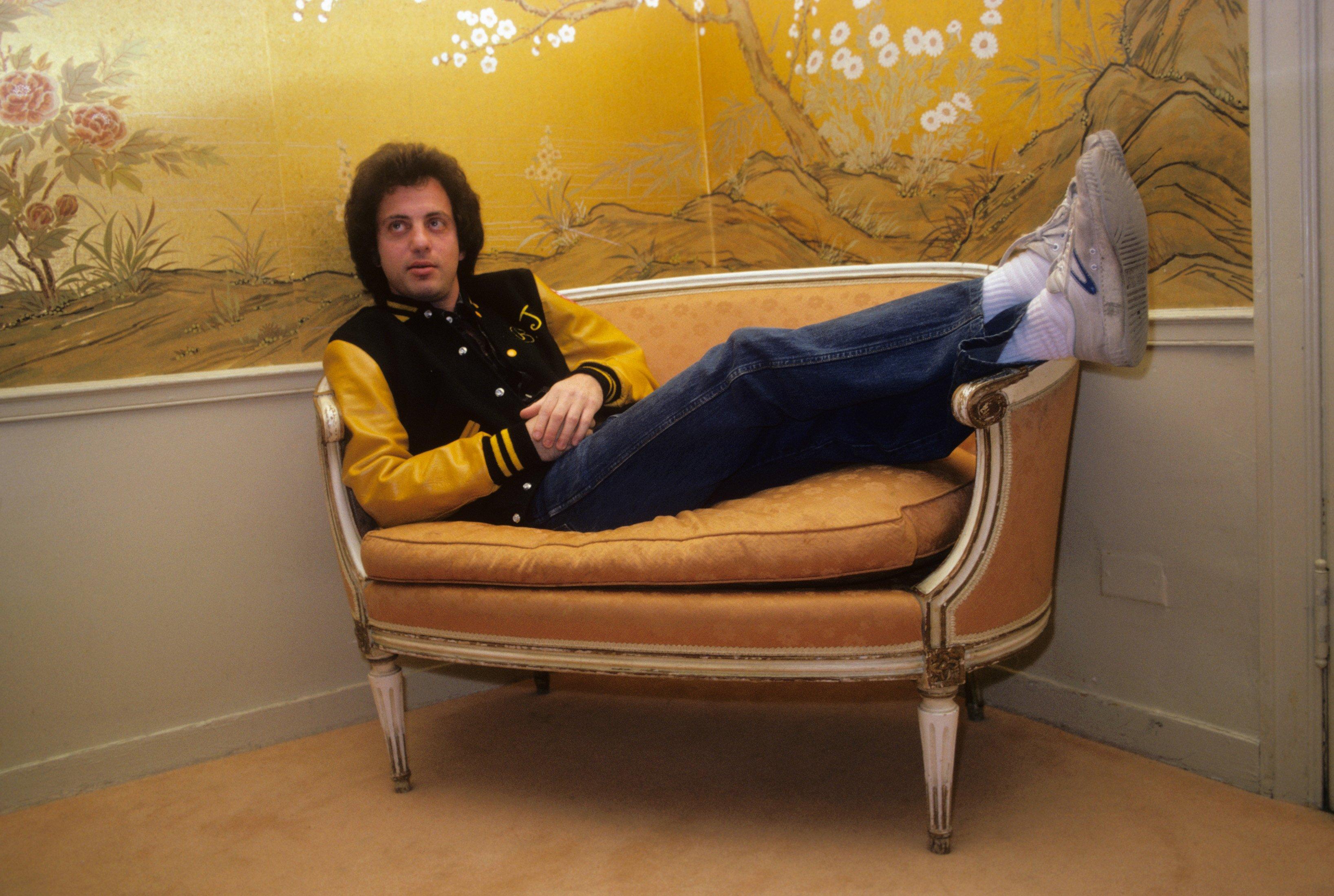 Billy Joel laying on a couch backstage Madison Square Garden