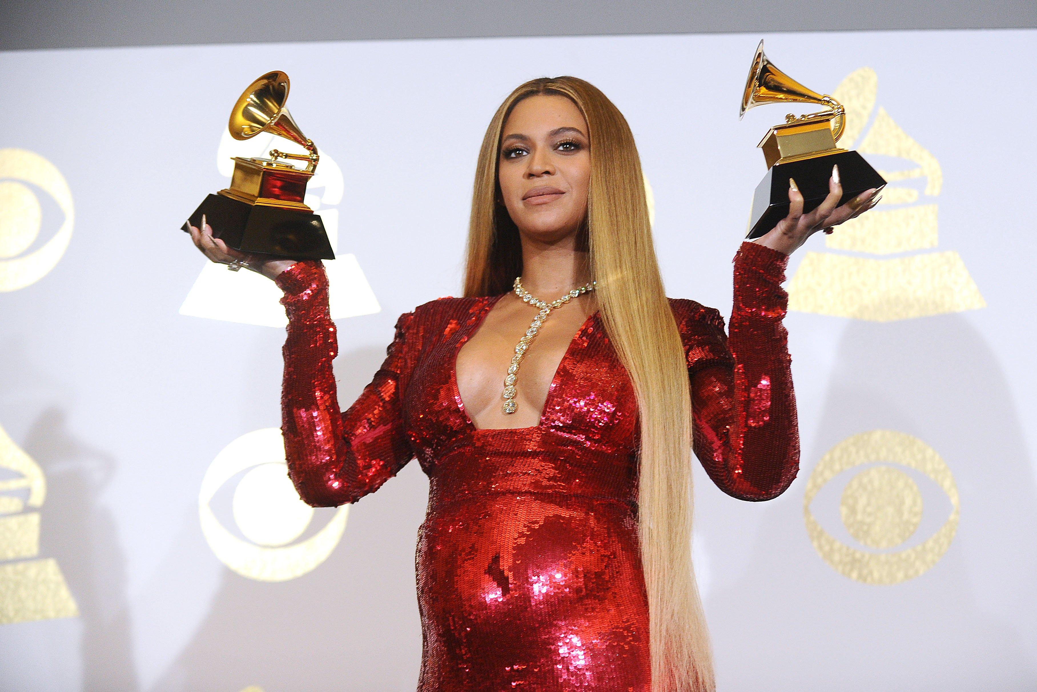 Beyoncé holds two GRAMMYs backstage at the 59th GRAMMYs
