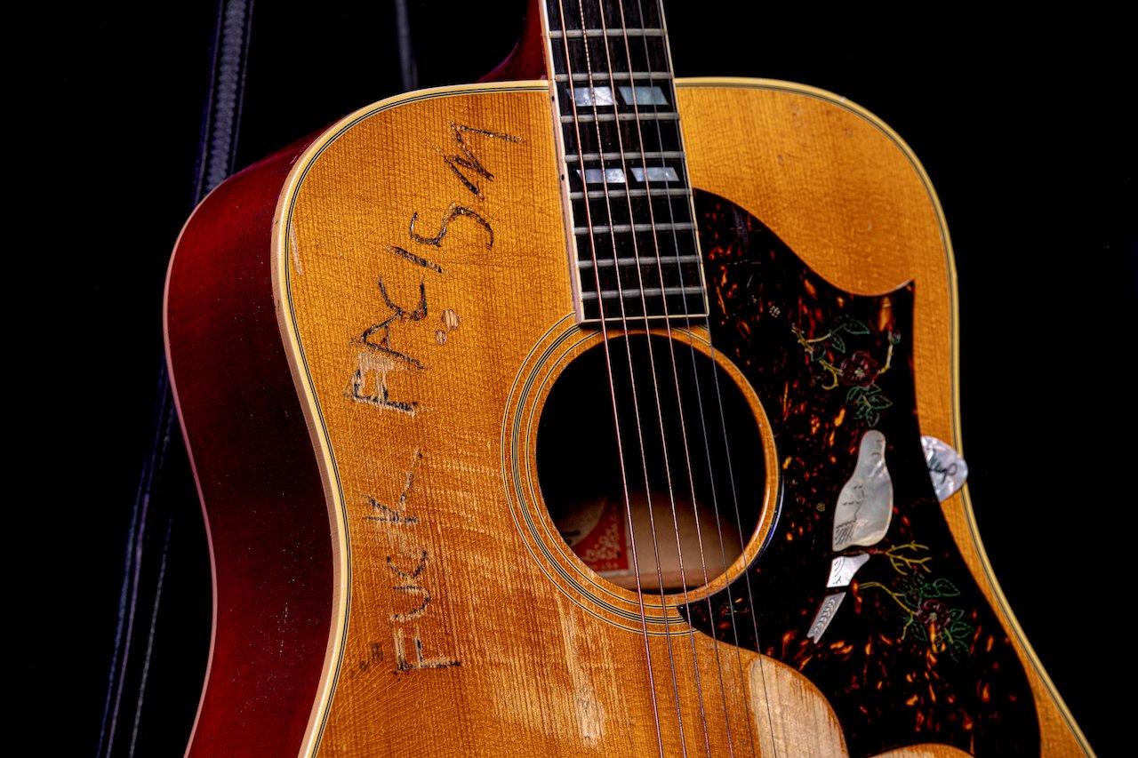 Photo of John Mellencamp's Gibson Dove Acoustic guitar with "Fuck Fascism" written on it