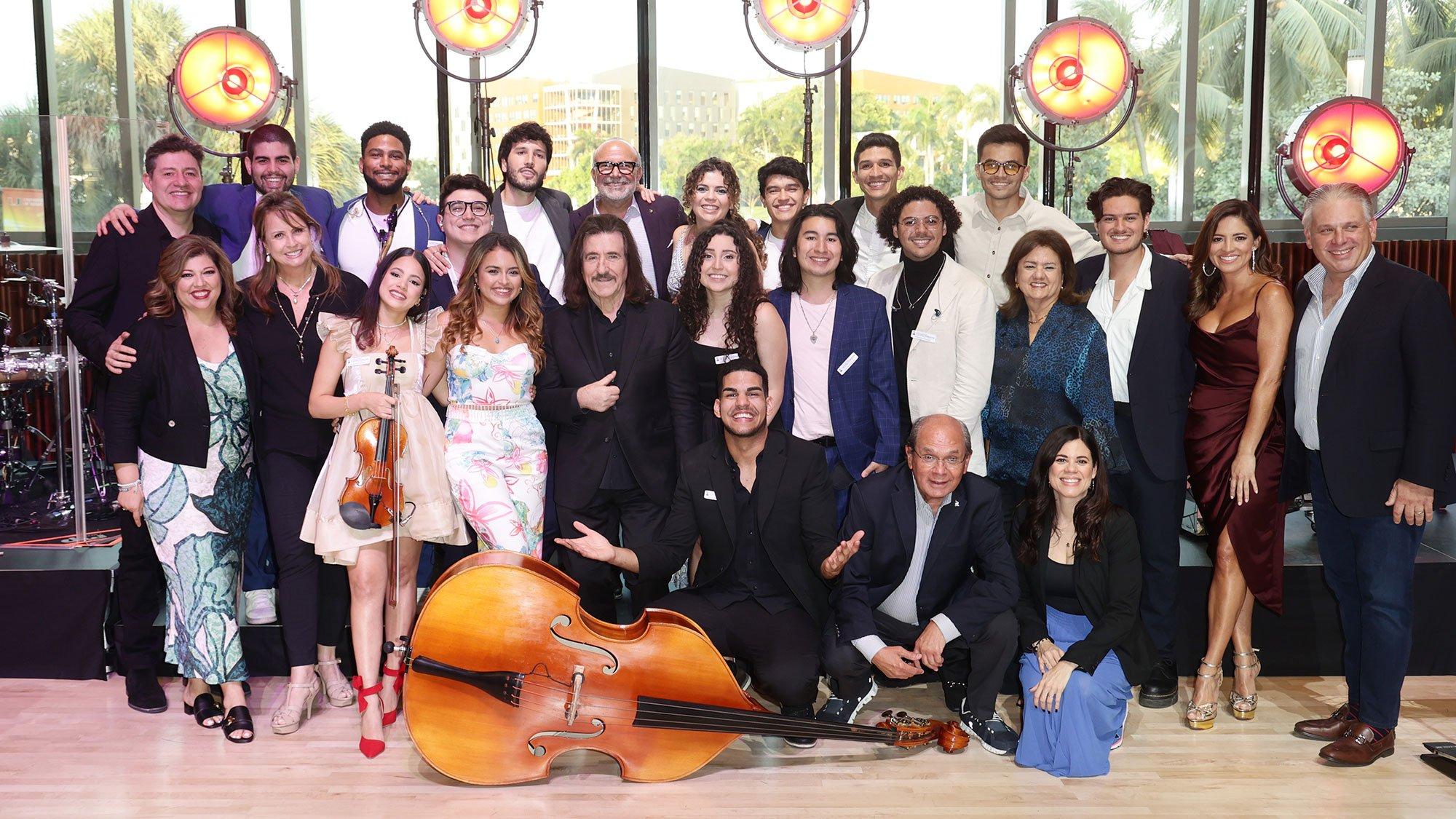 2024 Latin GRAMMY Cultural Foundation Scholarship Winners pose for a group photo with their instruments and Sebastián Yatra at the center