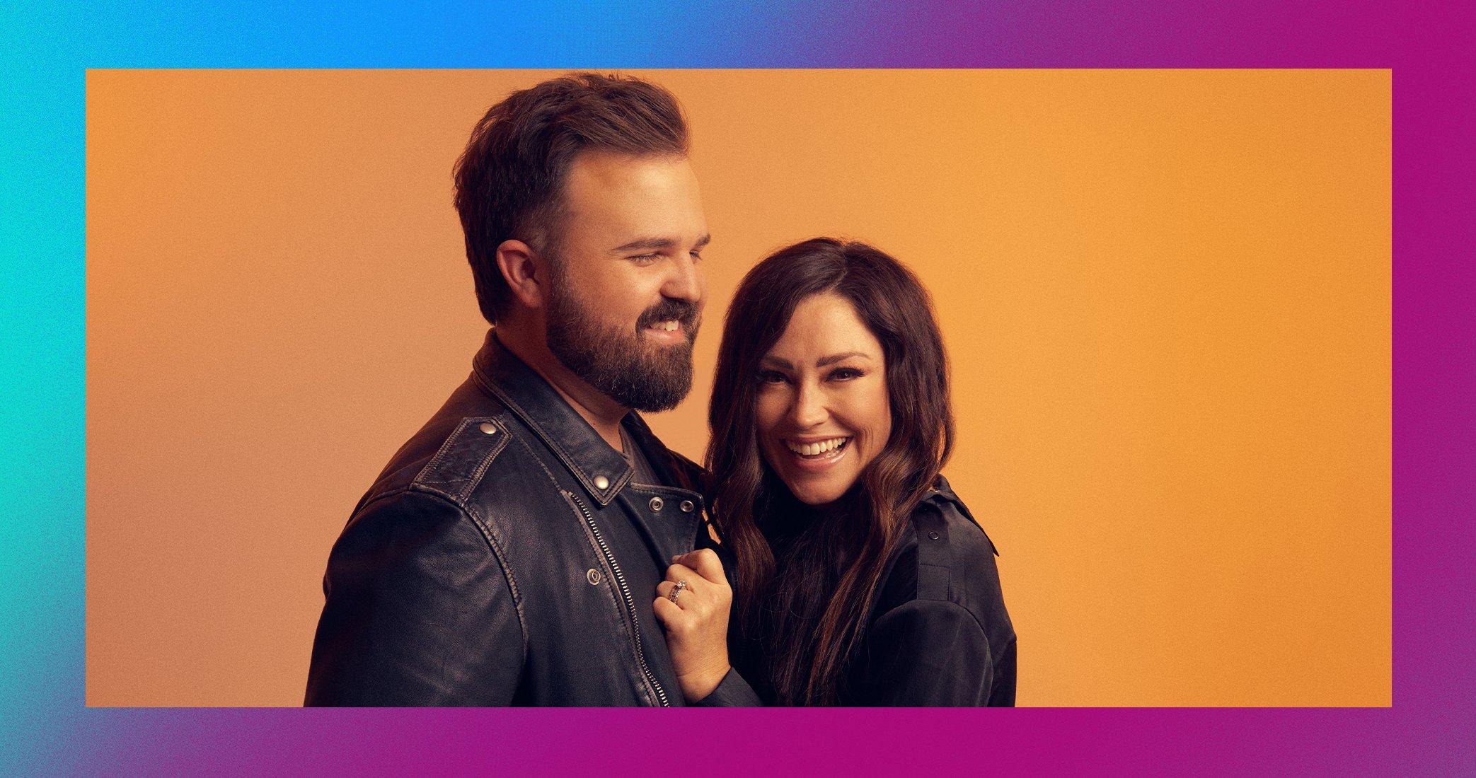 Kari Jobe and Cody Carnes smiling in front of colorful backdrop