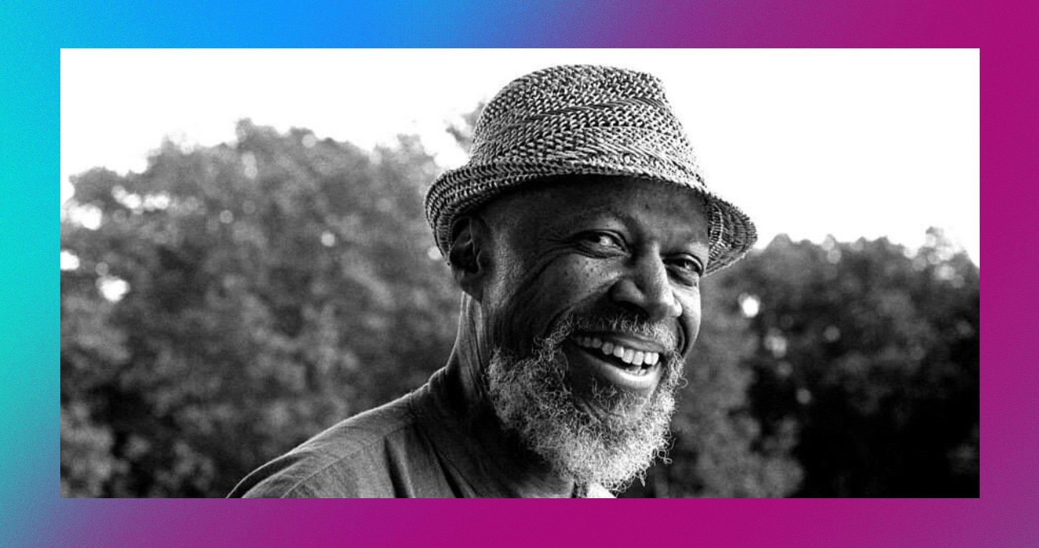 black and white photo of Laraaji smiling with a straw hat