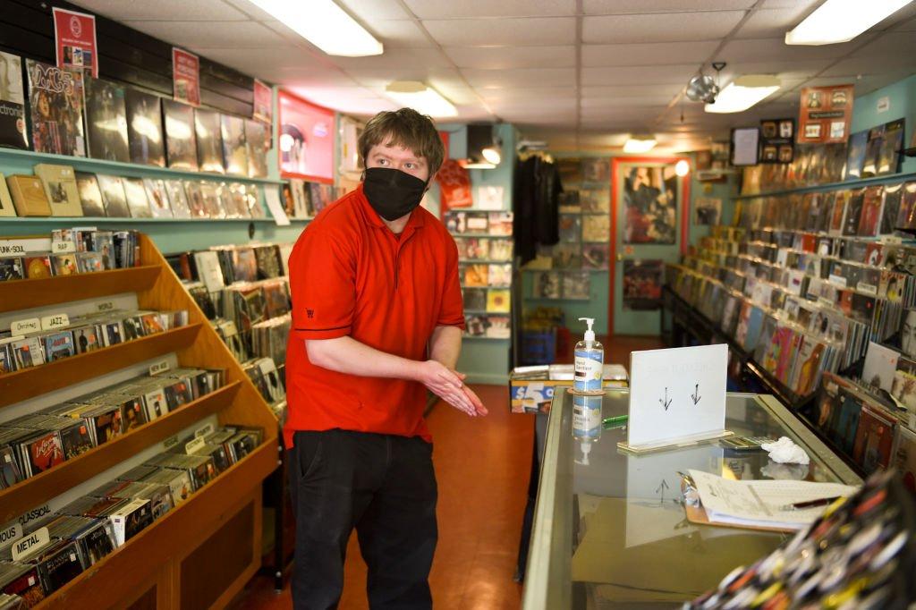 Nick Demangone of Exeter Township sanitizes his hands before browsing records for sale at Vertigo Music in West Reading
