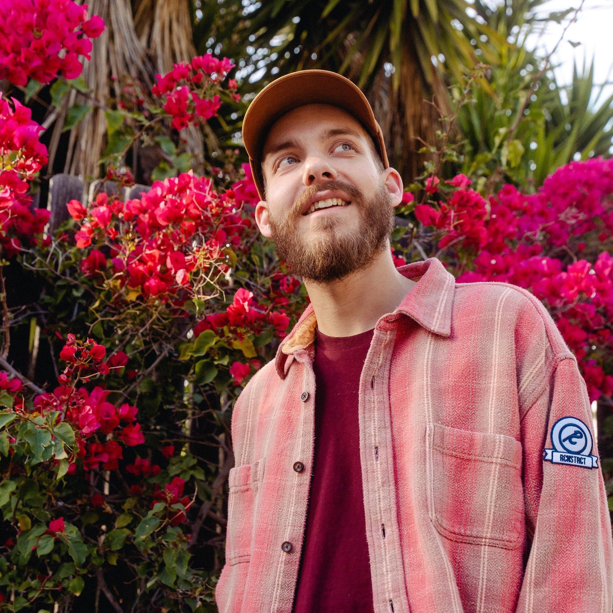 San Holo smiles in front of flowers