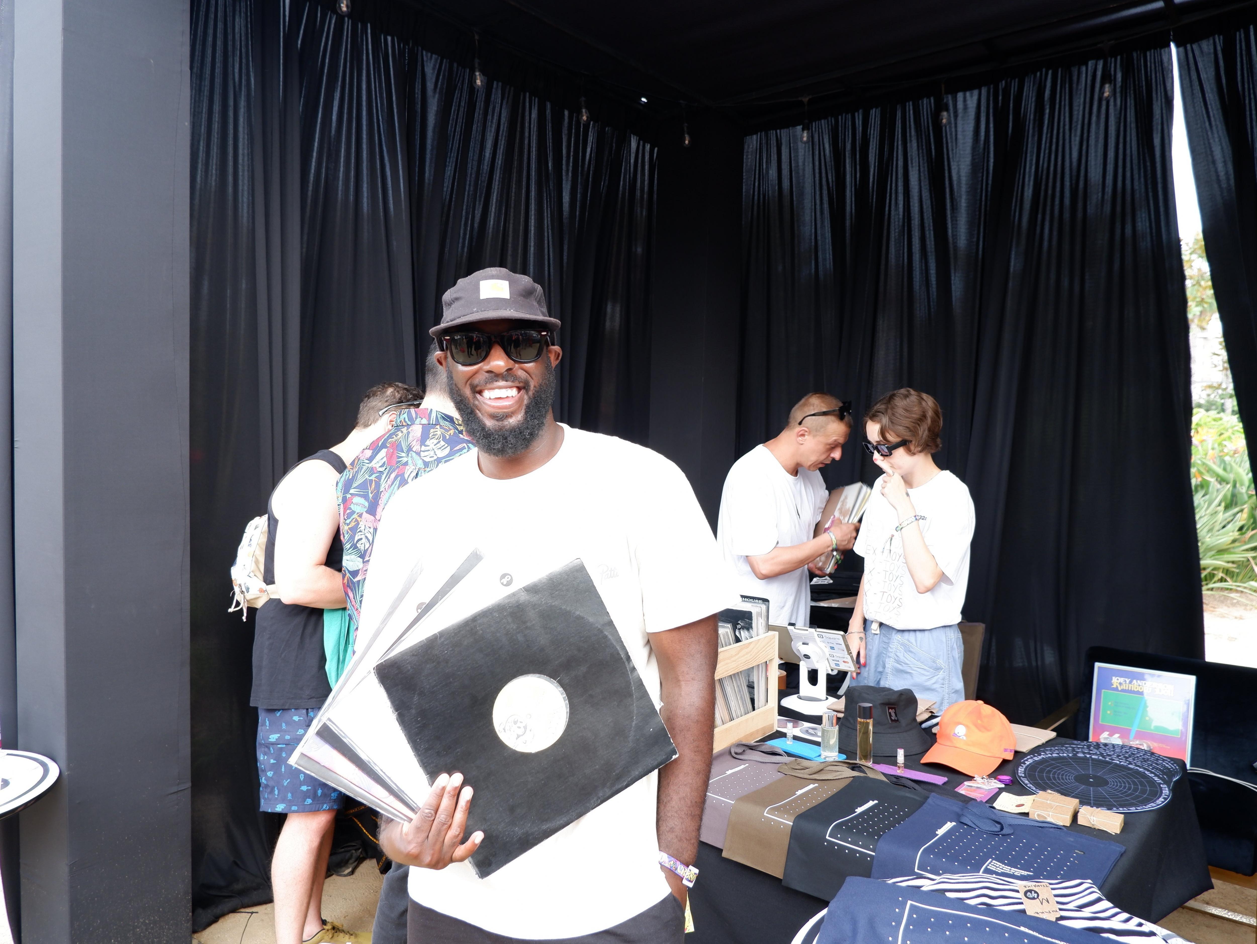 T.Williams holds up his vinyl selects in front of the Stellar Remnant pop-up at CRSSD Festival 2021