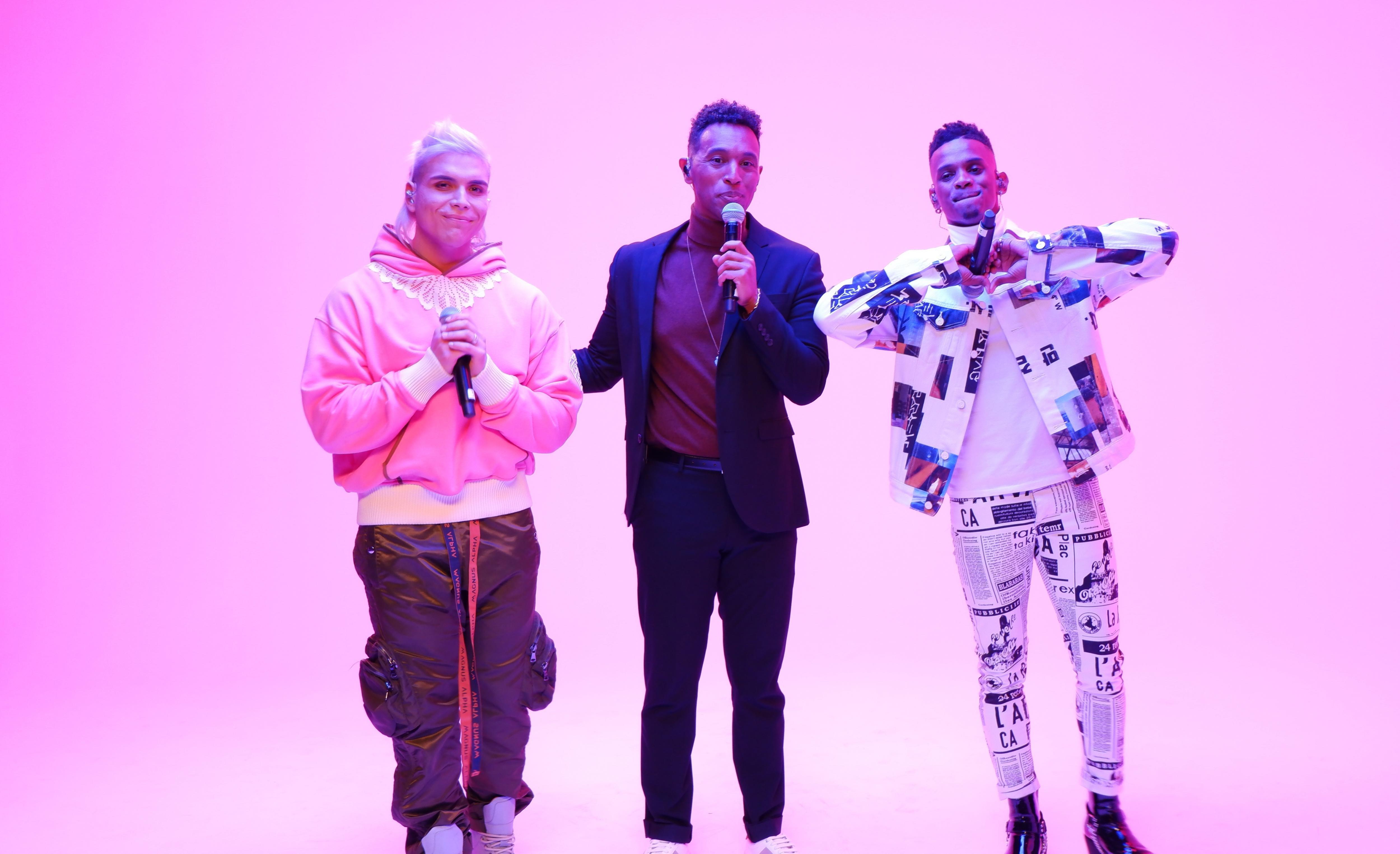 Tito Rey, Justin Michael Williams & ALONZO sing in front of a pink background