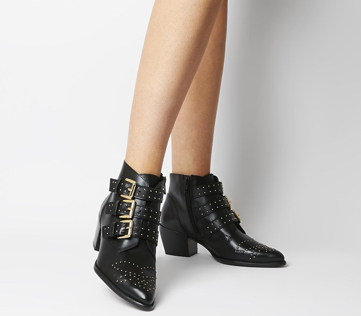 black booties with gold buckles