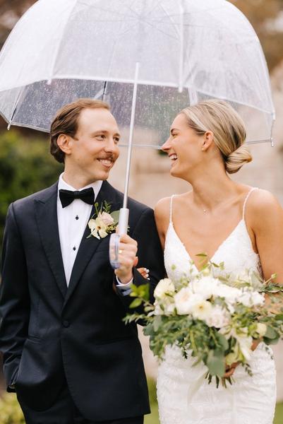 Grace and Curtis with clear umbrella on their rainy wedding day